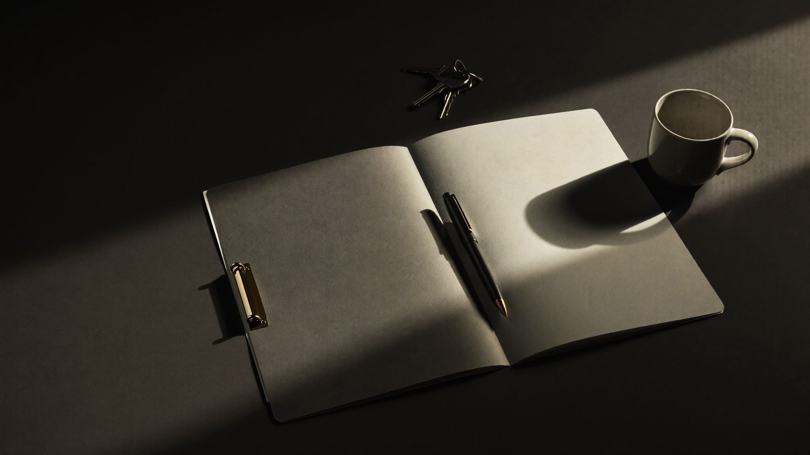A folder, pen and keys on a desk — deciding which marketing agency to hire